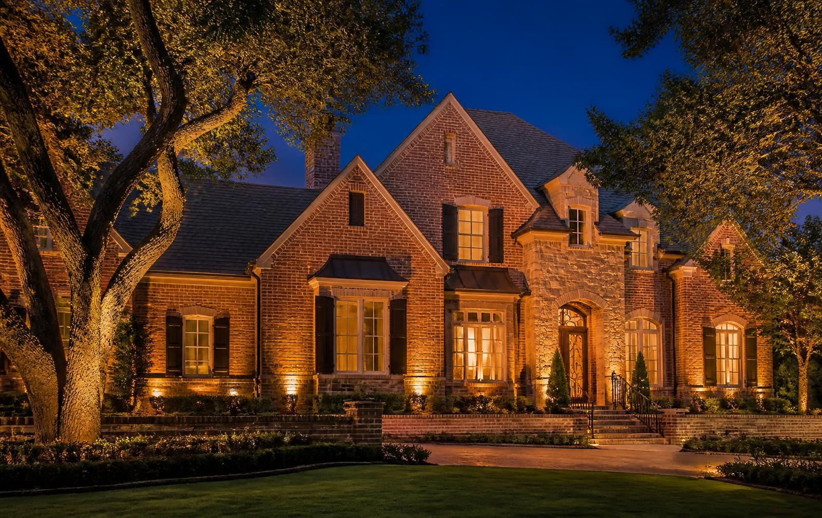 Luxury Huntsville home at dusk with warm amber architectural uplighting